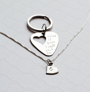 steel guitar pick keychain with heart cut out on a necklace