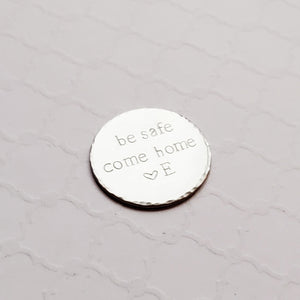 steel pocket token stamped with "be safe come home"